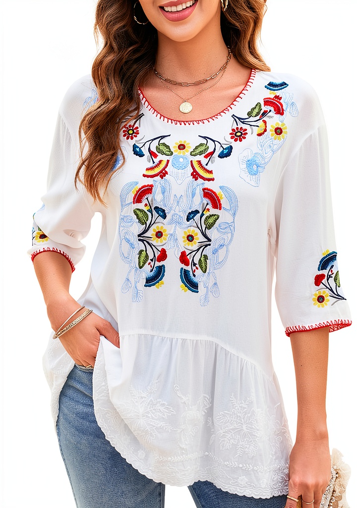 Embroidered womens top in white with floral design on a hanger